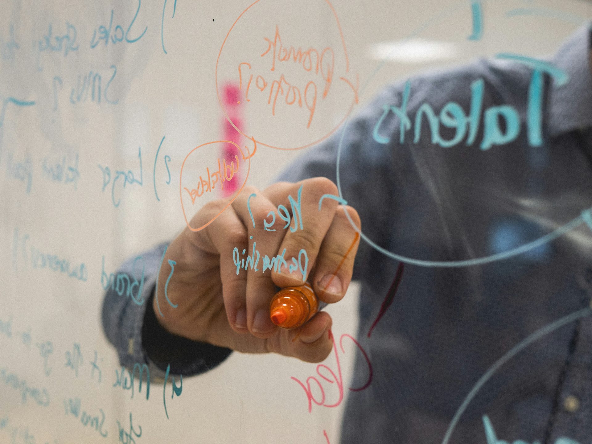 Hand writing with marker on a clear pane of glass